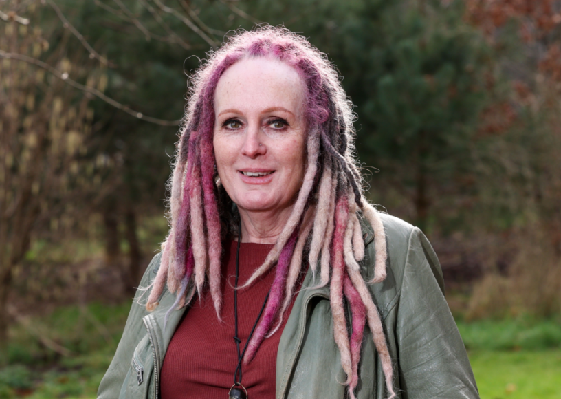 Woman smiles for a photograph while outdoors