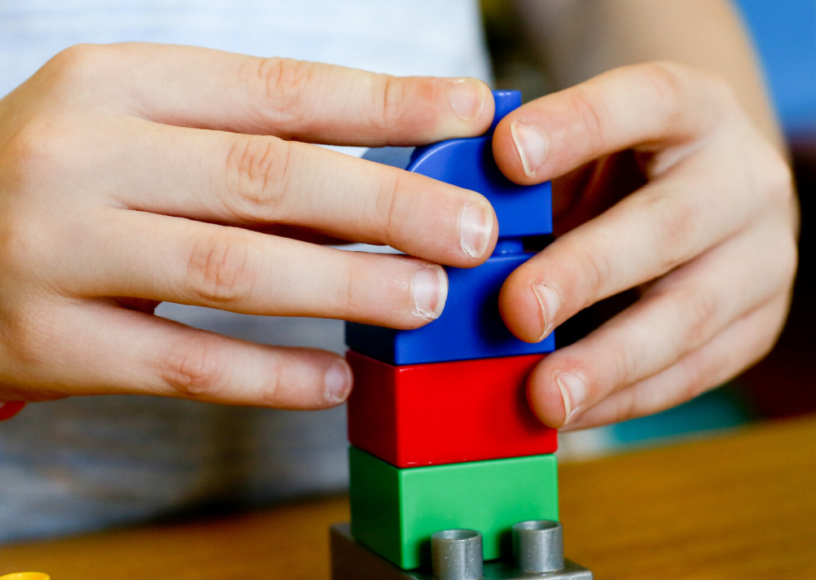 A child's hands using building blocks