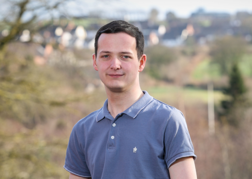 Young man outdoors smiling for a photograph