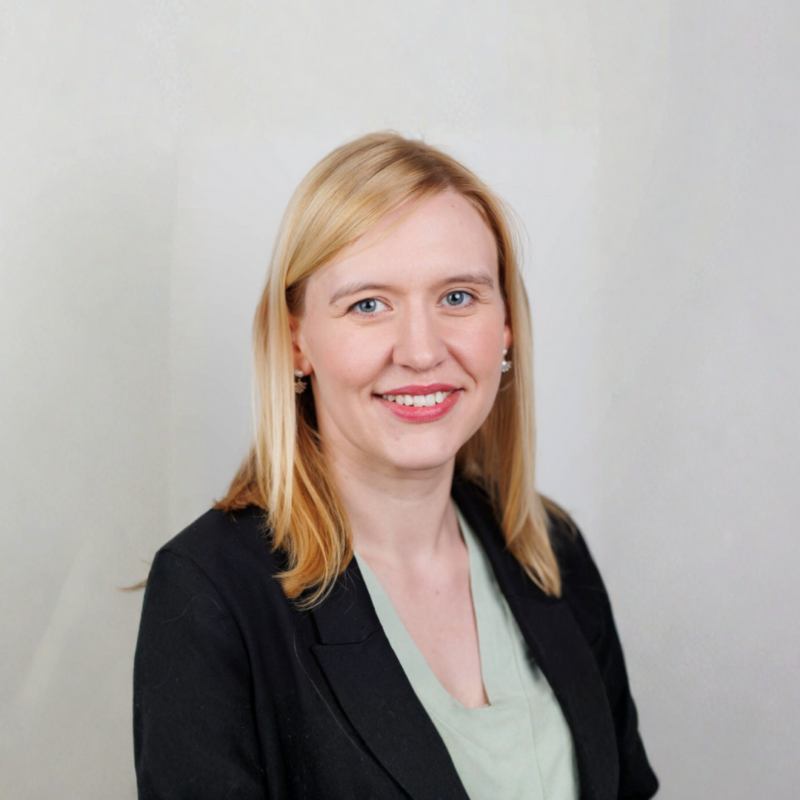 Headshot of Christine Kearney, looking at the camera with a beige background.