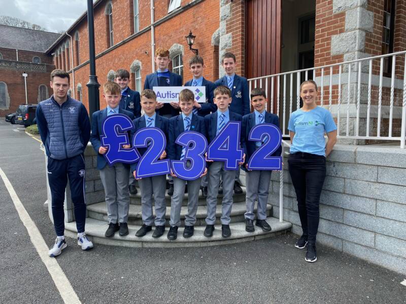 Students of St Colmans College, Newry smile and hold signs spelling '£2342'