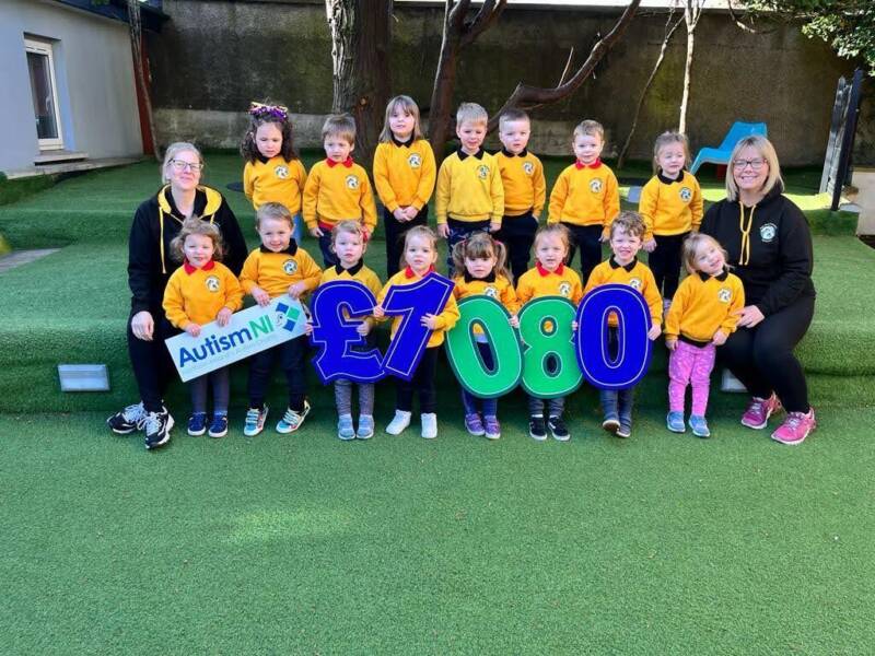 Staff and young school students hold up signs that spell £1080