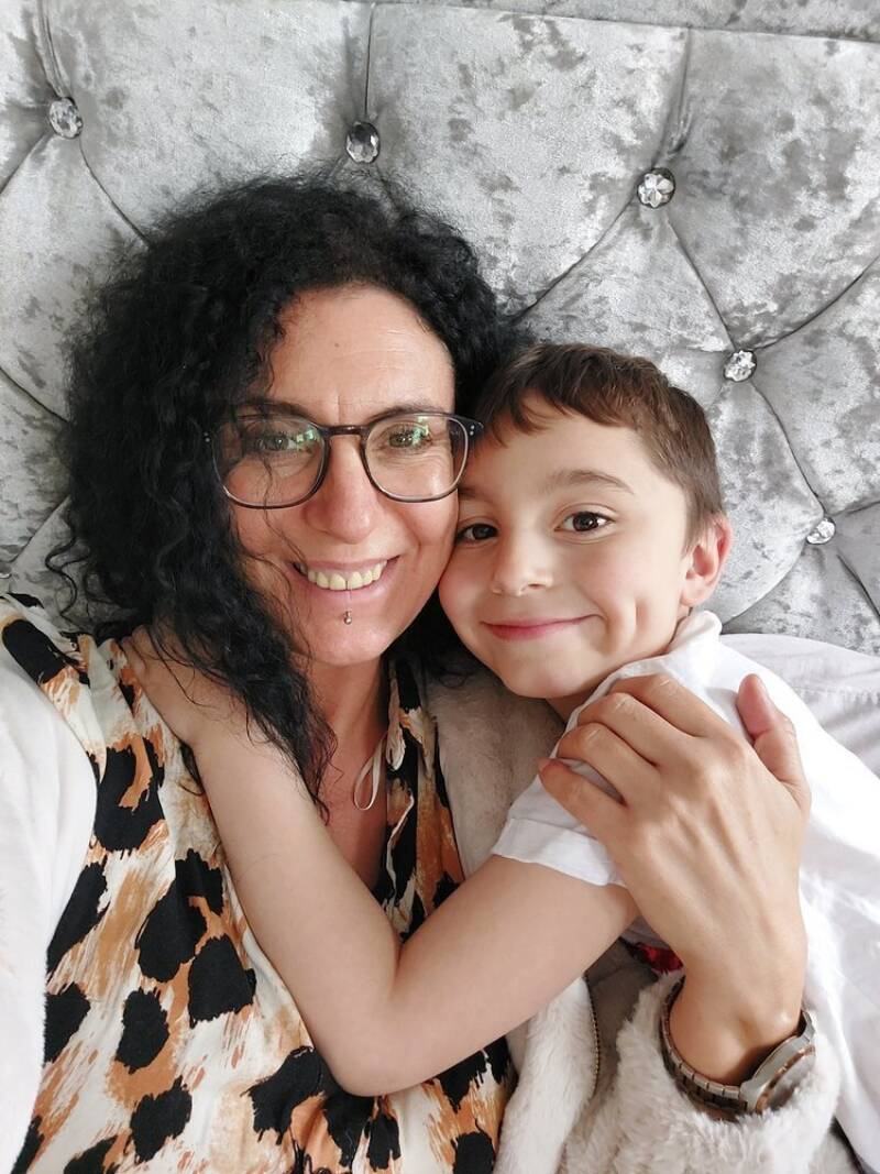 A mother and son hugging and smiling for a selfie