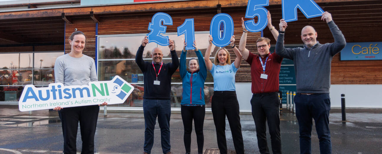 A group of people pose together outside a Home Bargains store