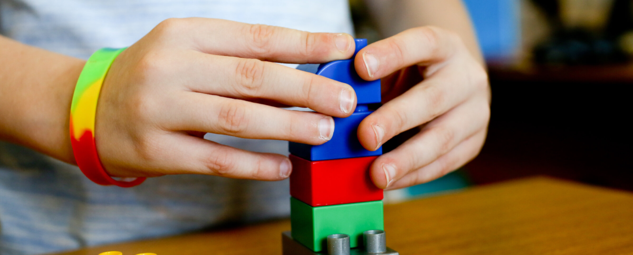 A child's hands using building blocks