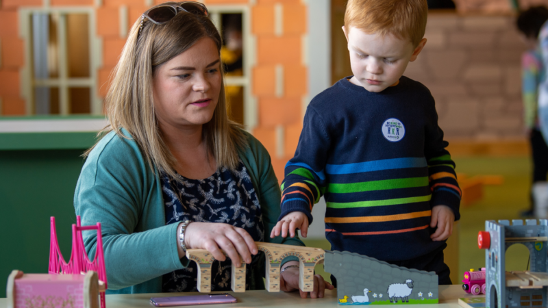 Mother and son play with toys together