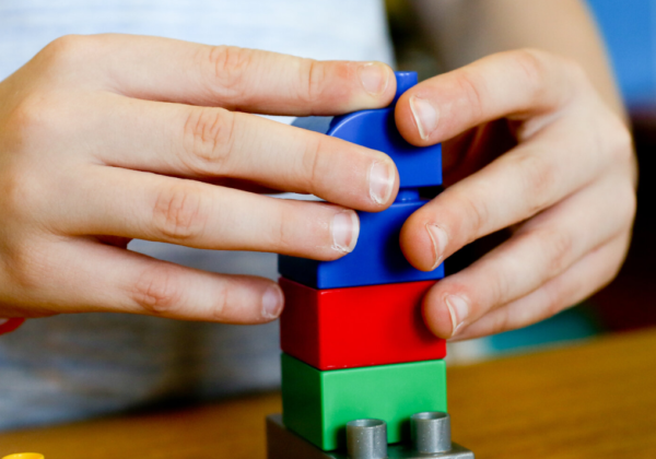 A child's hands using building blocks