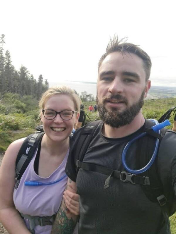 A couple smiling together as they climb the Mourne mountains