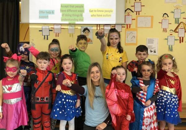 A group of children posing dressed as superheroes