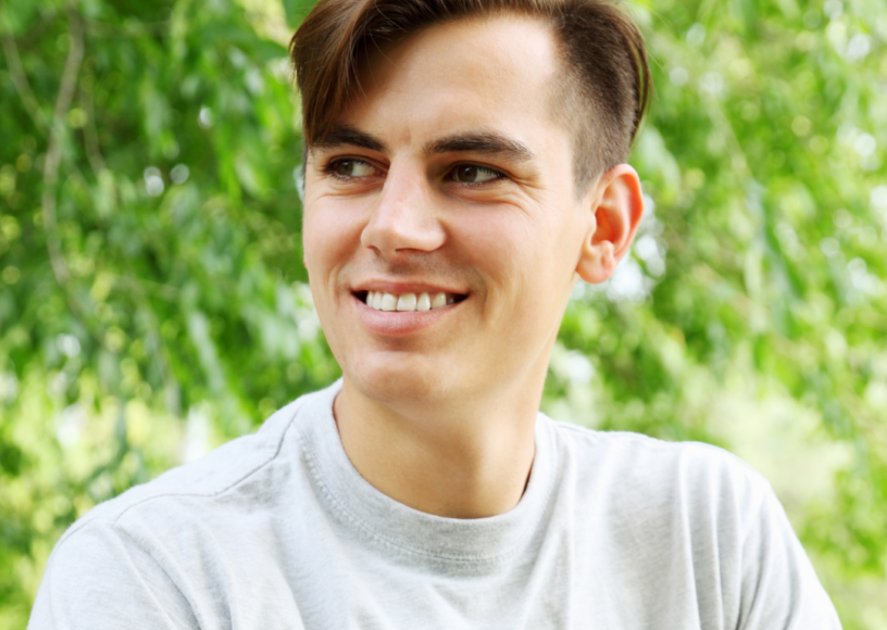 An adult male looking to right, smiling and content.